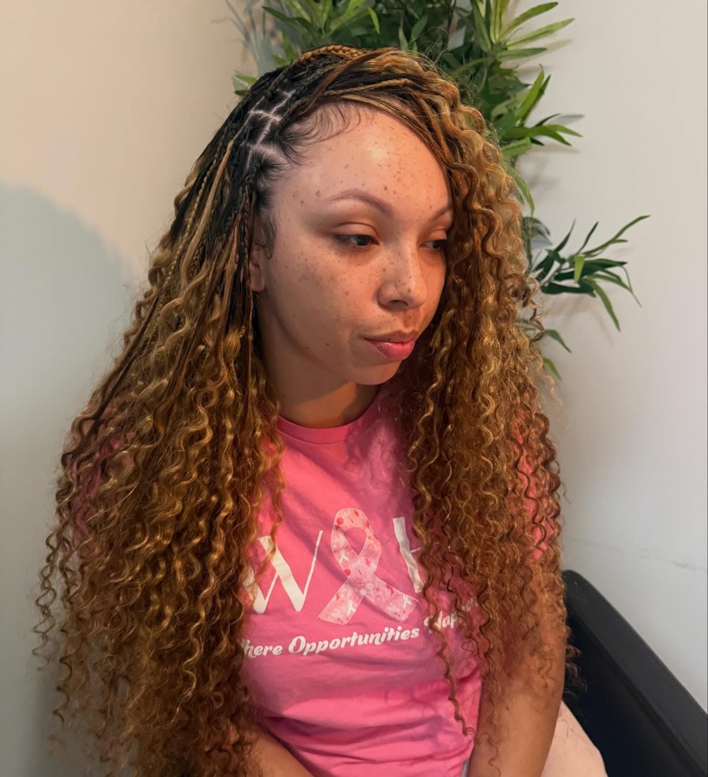 Long honey-toned curls falling in dense spirals from a centre part, styled full and past the chest