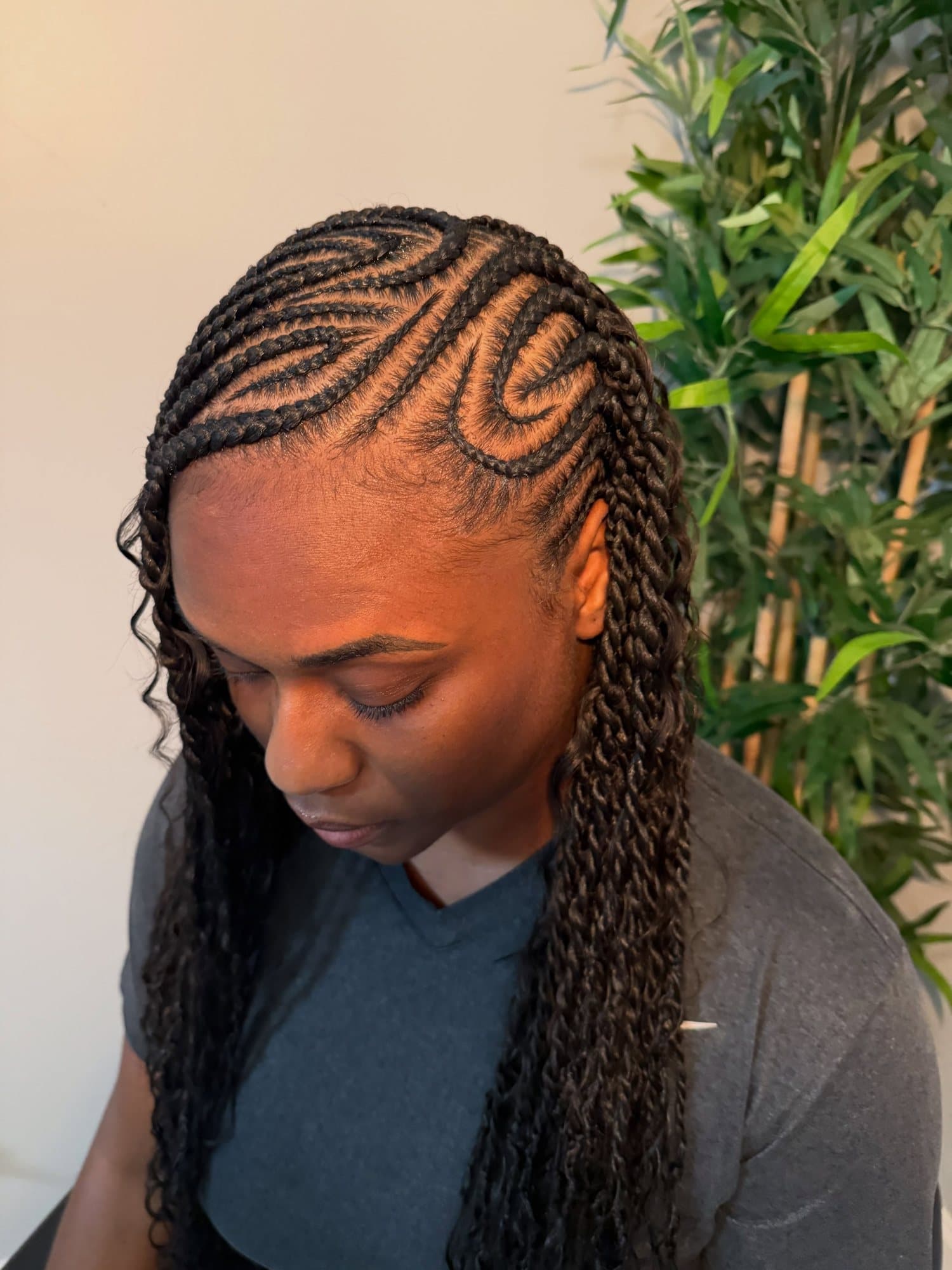 Fulani cornrows with swirled partings at the crown and boho twists falling long past the shoulder