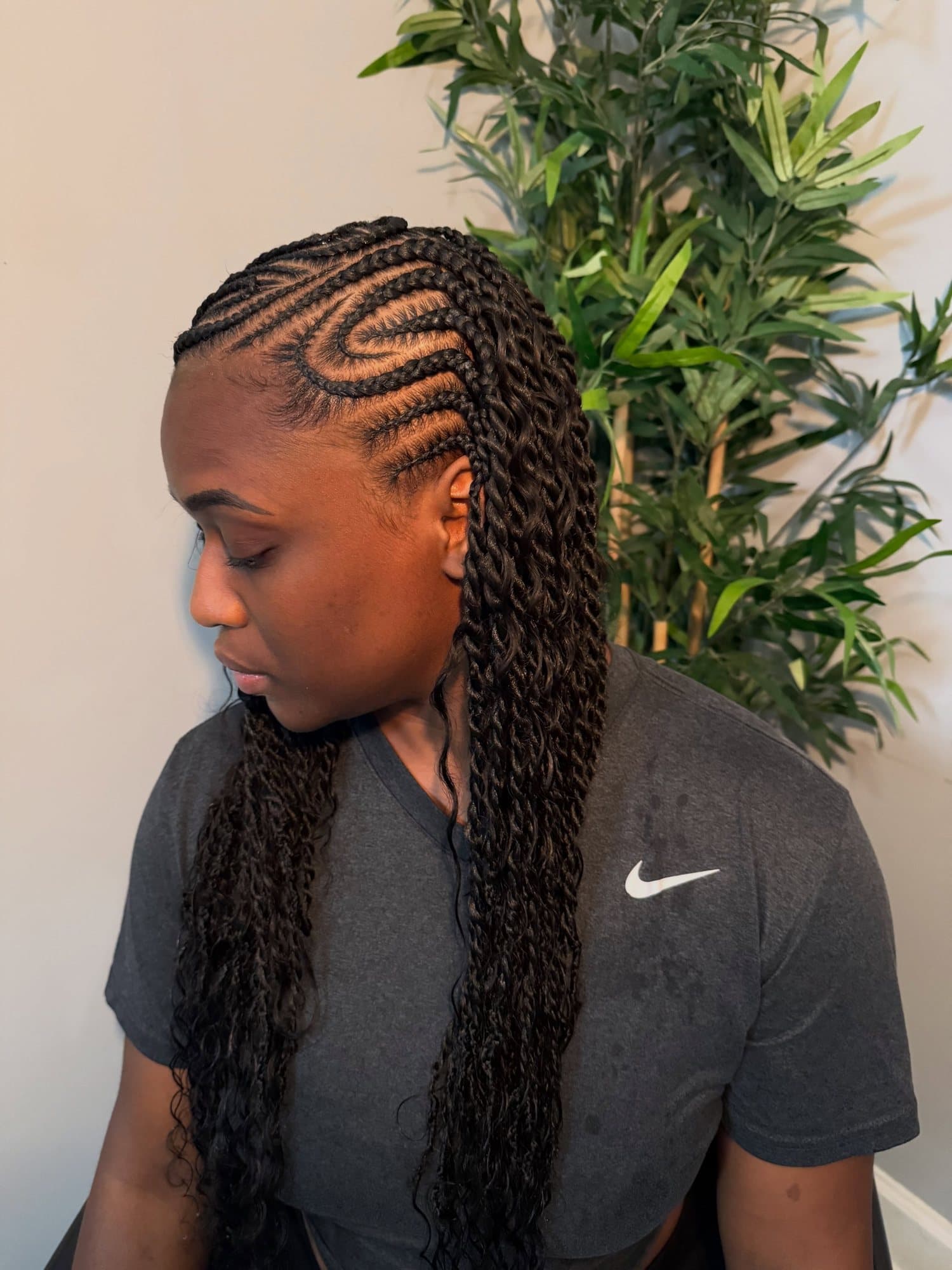 Three-quarter view of Fulani braids showing the swirl pattern at the temple and twisted lengths gathered behind the shoulder