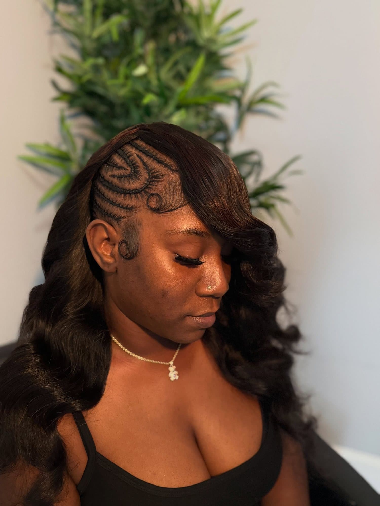 Curved cornrow partings swirling across the crown in a geometric pattern, finished with a long sleek wave